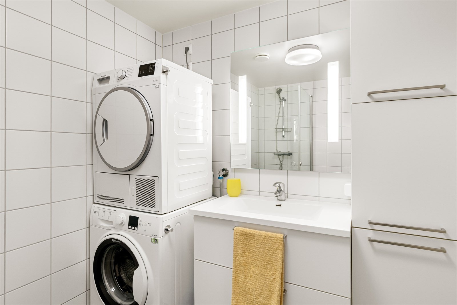 Opplegg til vaskemaskin og tørketrommel samt godt med oppbevaringsmuligheter i skuffer og skap Galleribilde