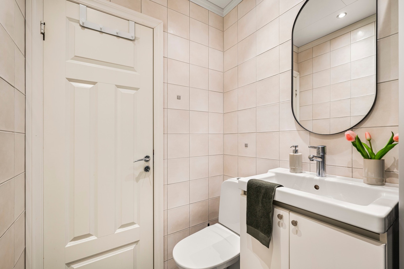 Badet inneholder toalett, helstøpt servant, skap under servant med slette fronter og dusjkabinett. Galleribilde