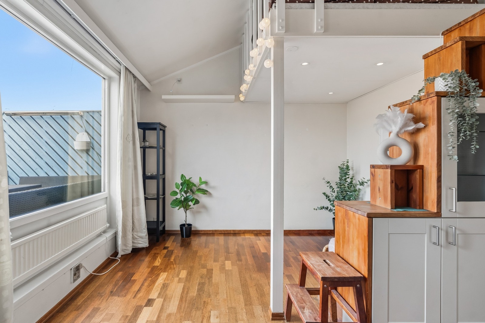 Trappen til hemsen har praktisk oppbevaring og bidrar samtidig til en naturlig inndeling mellom stue- og kjøkkendelen. Galleribilde