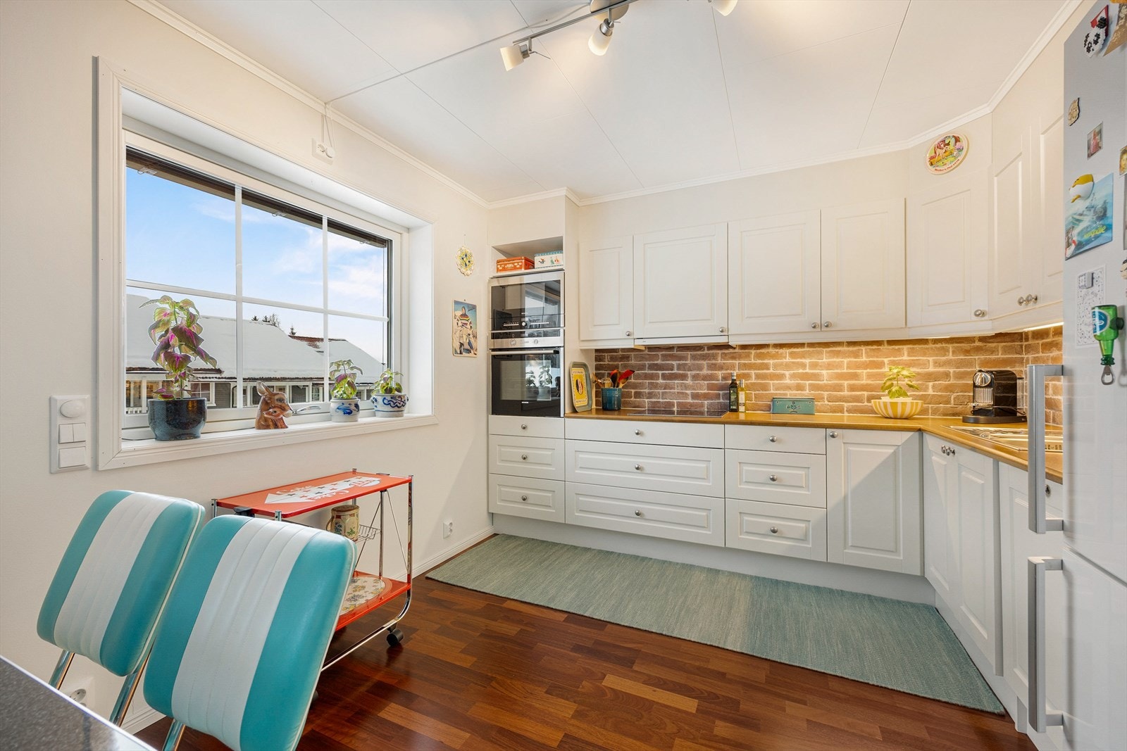 Innredningen består av hvite, klassiske fronter, laminat benkeplate og belysning under overskap. Galleribilde