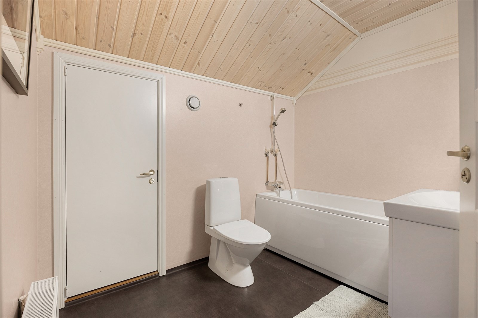 Badet er utstyrt med toalett, servant med skuff og badekar med dusjløsning. Galleribilde