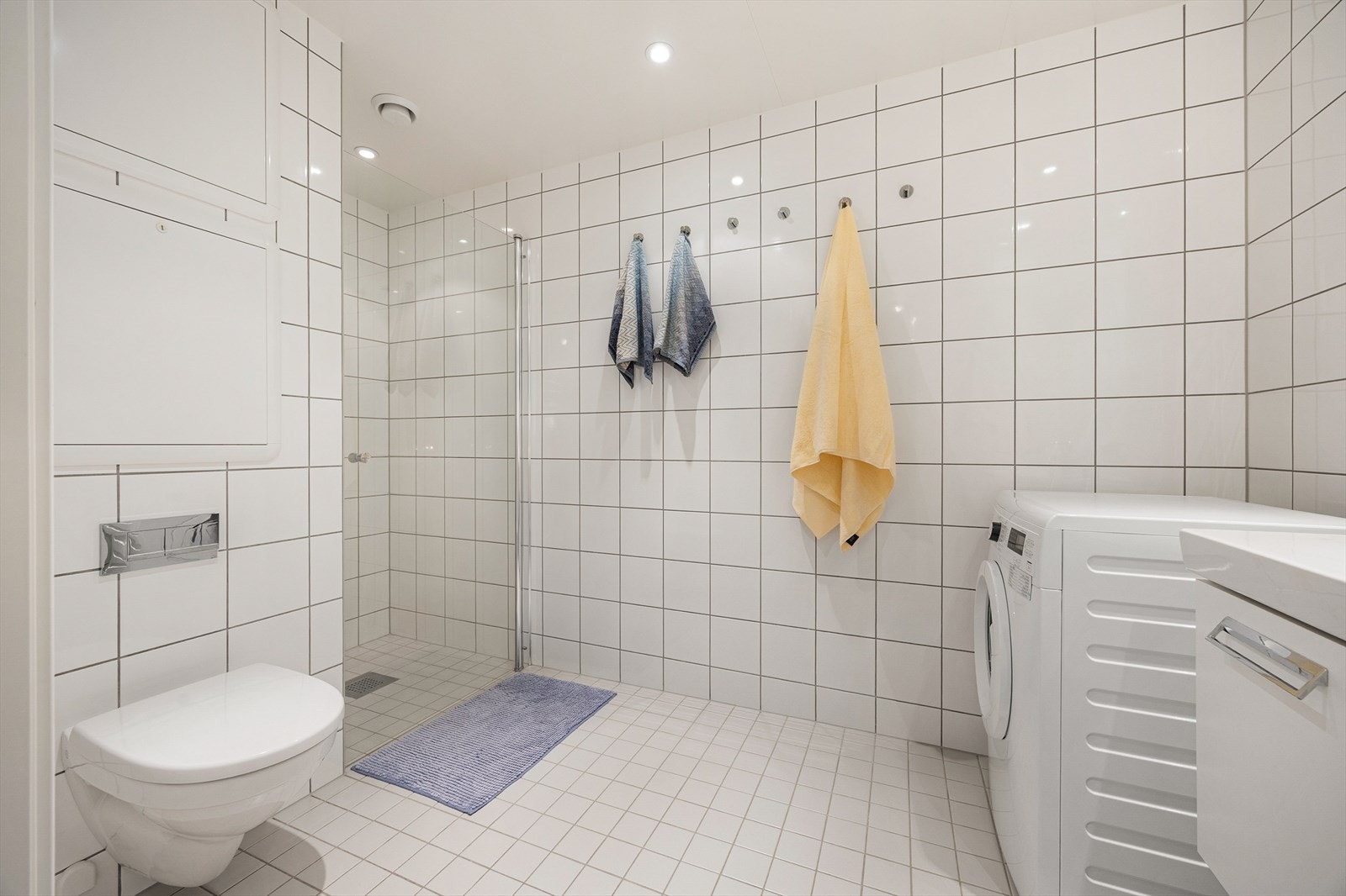 Pent flislagt baderom med varme i gulv og downlights i tak. Galleribilde