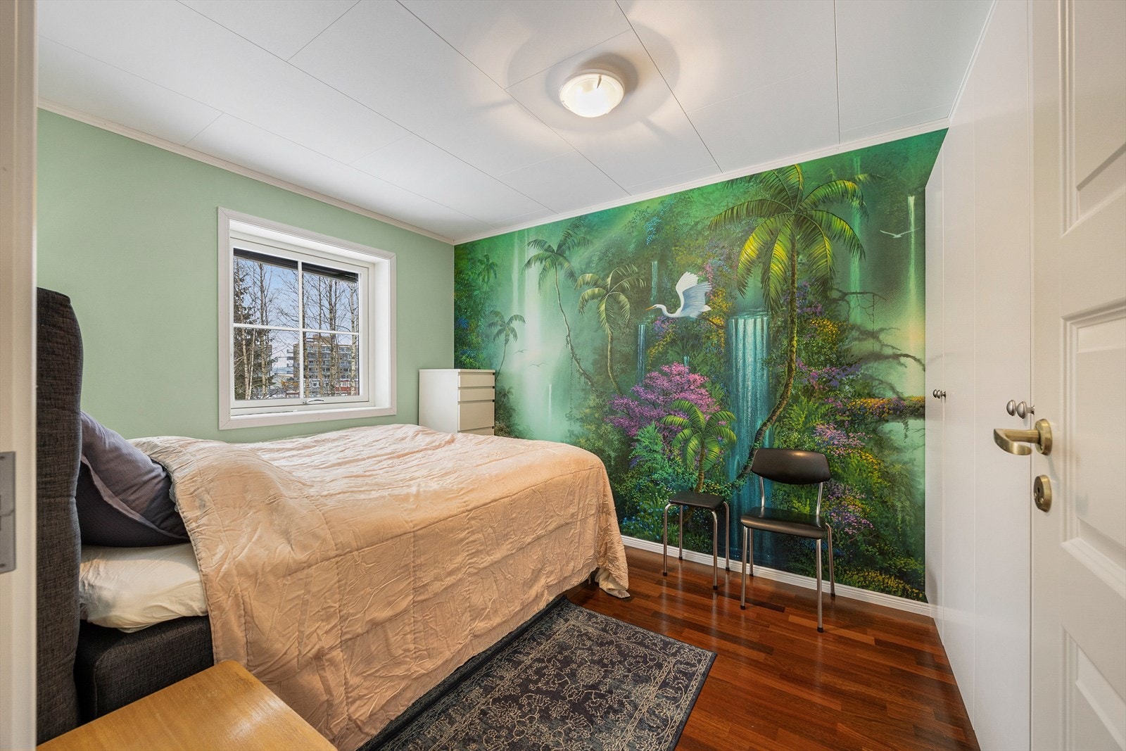 Hovedsoverommet er møblert med seng, garderobe og kommode og har en kontrastvegg med tapet. Galleribilde