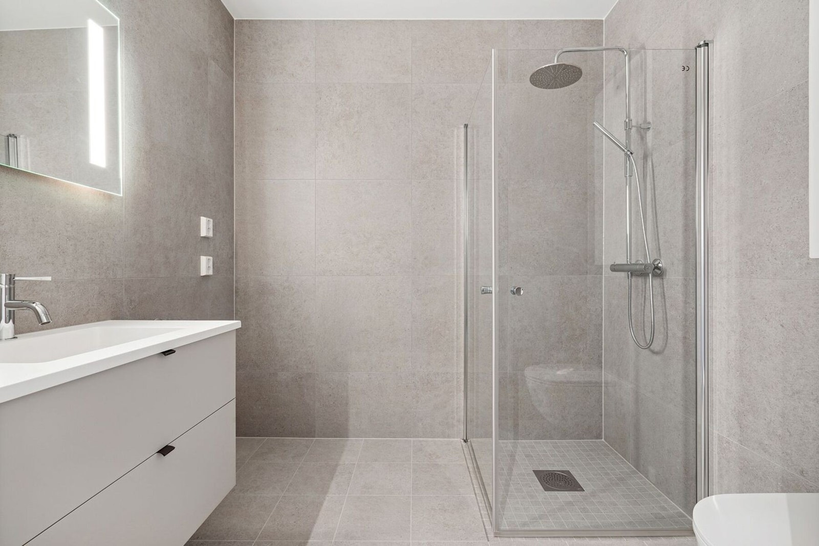 Pent plassbygd bad med store fliser. Galleribilde