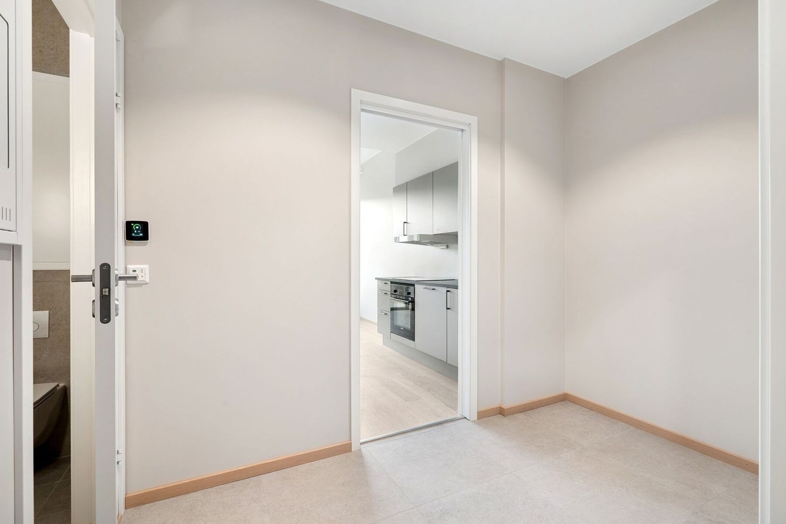 Romslig og flislagt entré på 5,2 m² med god plass til garderobeløsning. Døren til venstre i bildet leder til leilighetens bad. Galleribilde