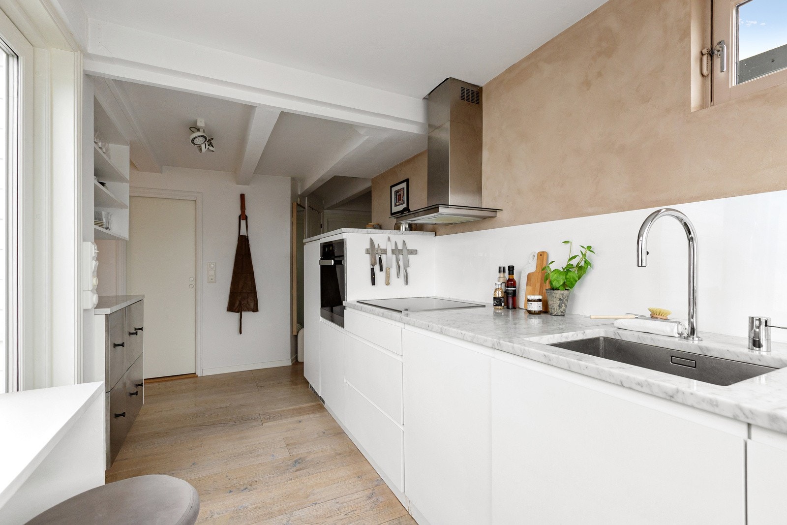 Kjøkkenet er utstyrt med integrerte hvitevarer, herunder kjøleskap, oppvaskmaskin, platetopp og stekeovn, som gir et ryddig og gjennomført preg. Galleribilde