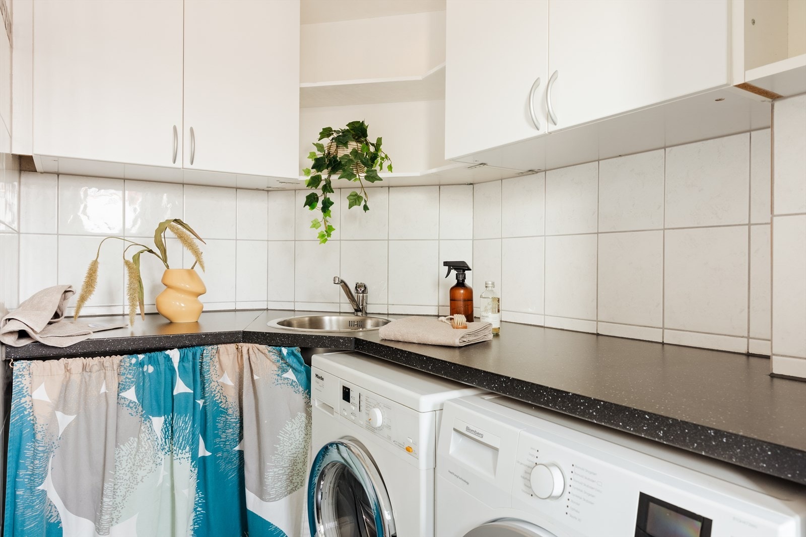 Badet har en praktisk planløsning med egnet område for klesvask og oppbevaring Galleribilde