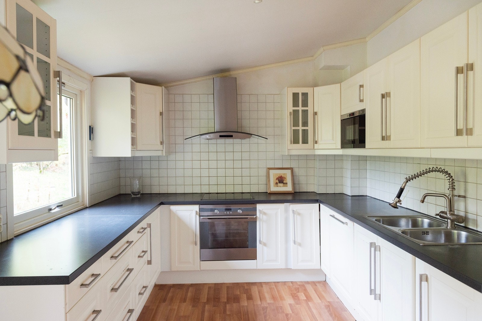 Kjøkkenet er lyst og pent, med mye skap- og benkeplass Galleribilde