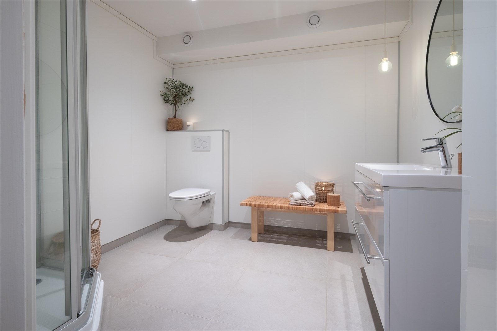 Renovert bad har store gulvfliser, varmekabler og avtrekk via felles anlegg Galleribilde