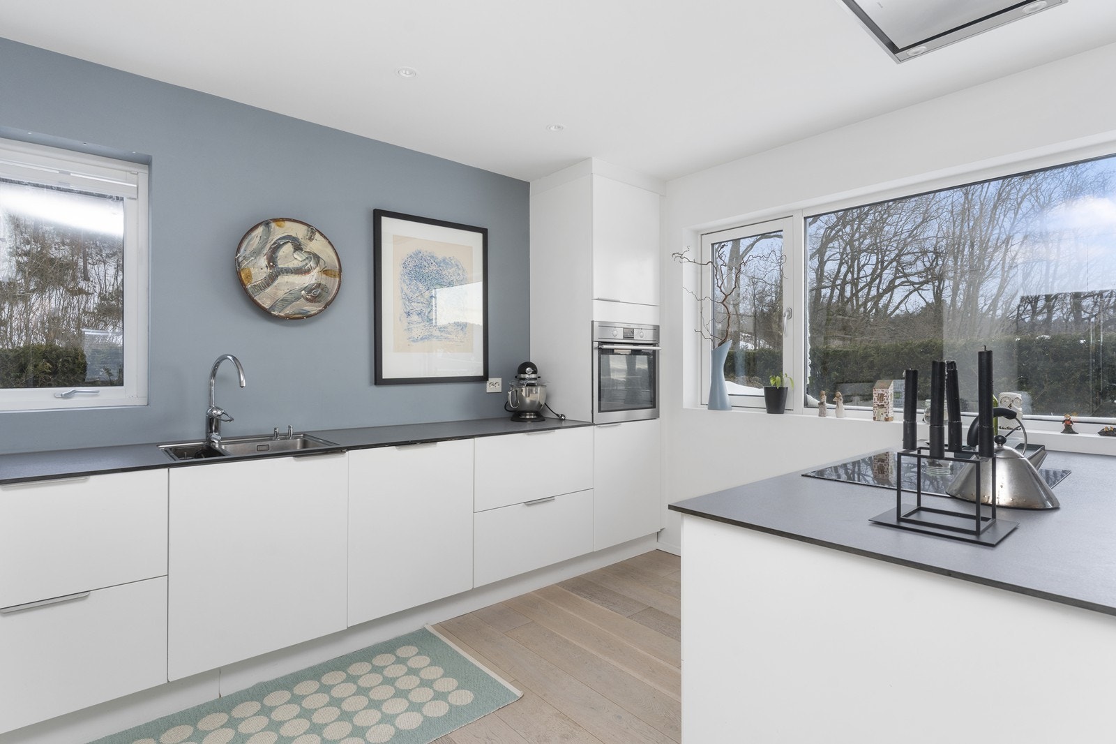 Pent kjøkken med stilrene overflater. God benkeplass og integrerte hvitevarer. Galleribilde