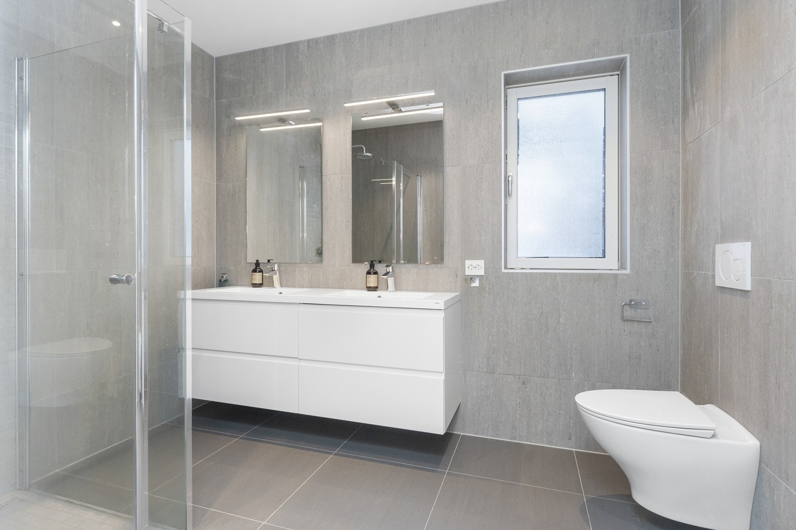 Flott bad med blant annet vegg-hengt WC og dobbelt servant. Galleribilde