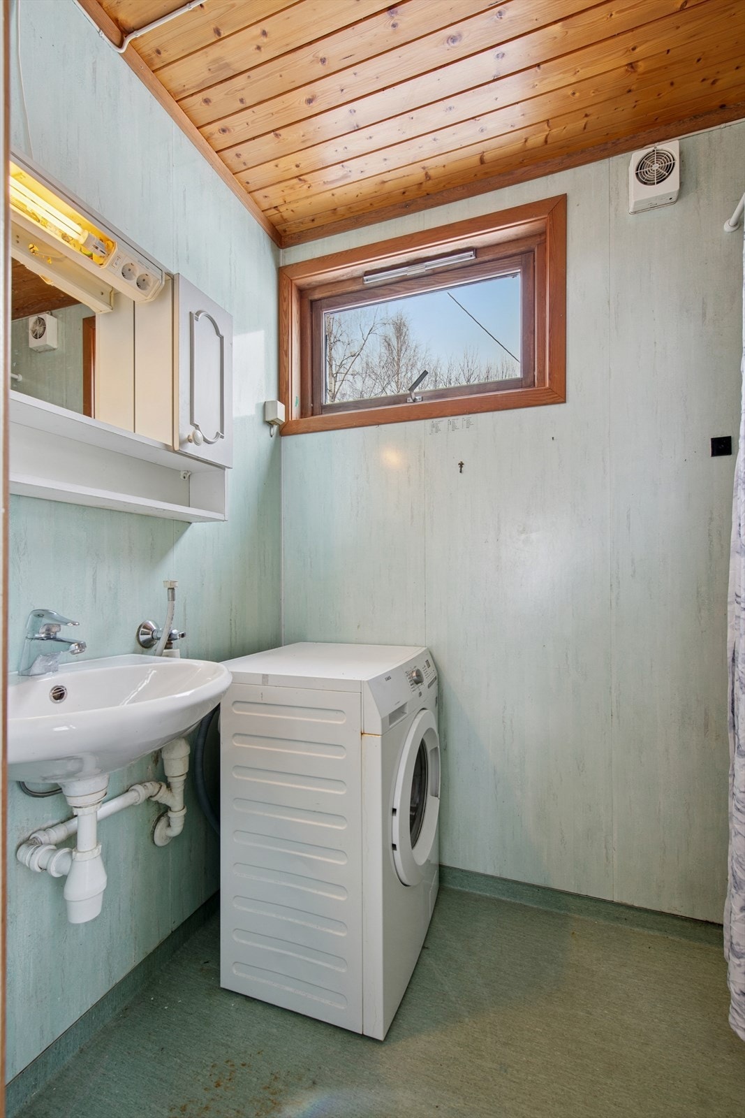 Badet har belegg på gulvet, baderomsplater på veggene og panel i himling. Galleribilde