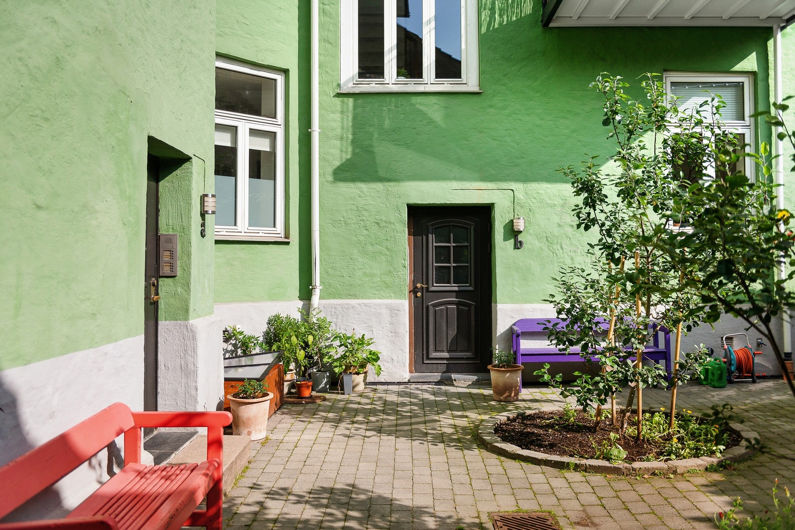 En flott og forseggjort bakgård med beplantning, grøntarealer og sitteplasser. Galleribilde