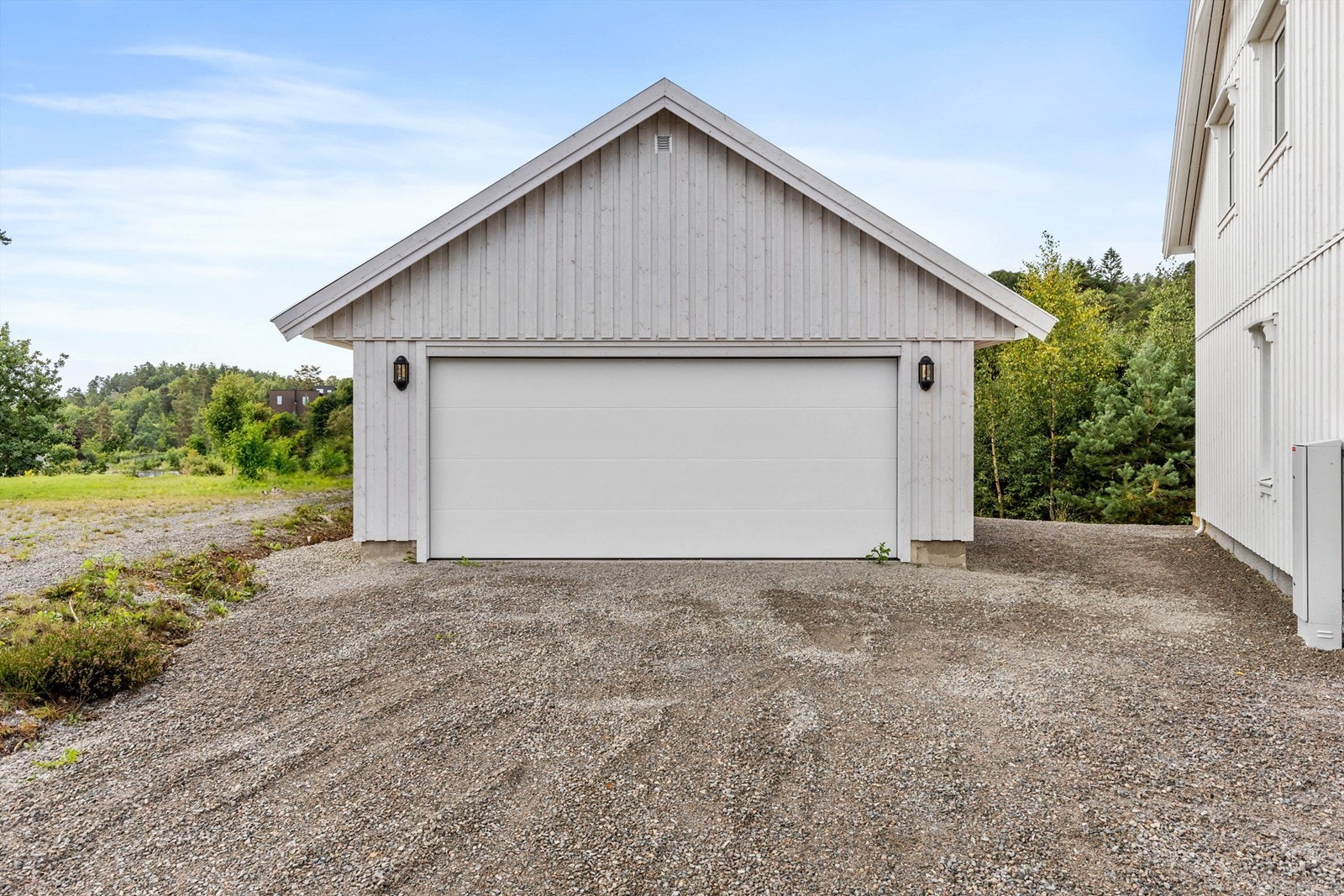 Dobbel garasje med el-porter og gruset tun. Galleribilde