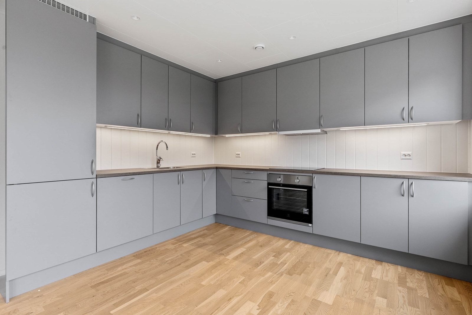 Moderne kjøkken med mye skap- og benkplass. Takhøye skap. Galleribilde