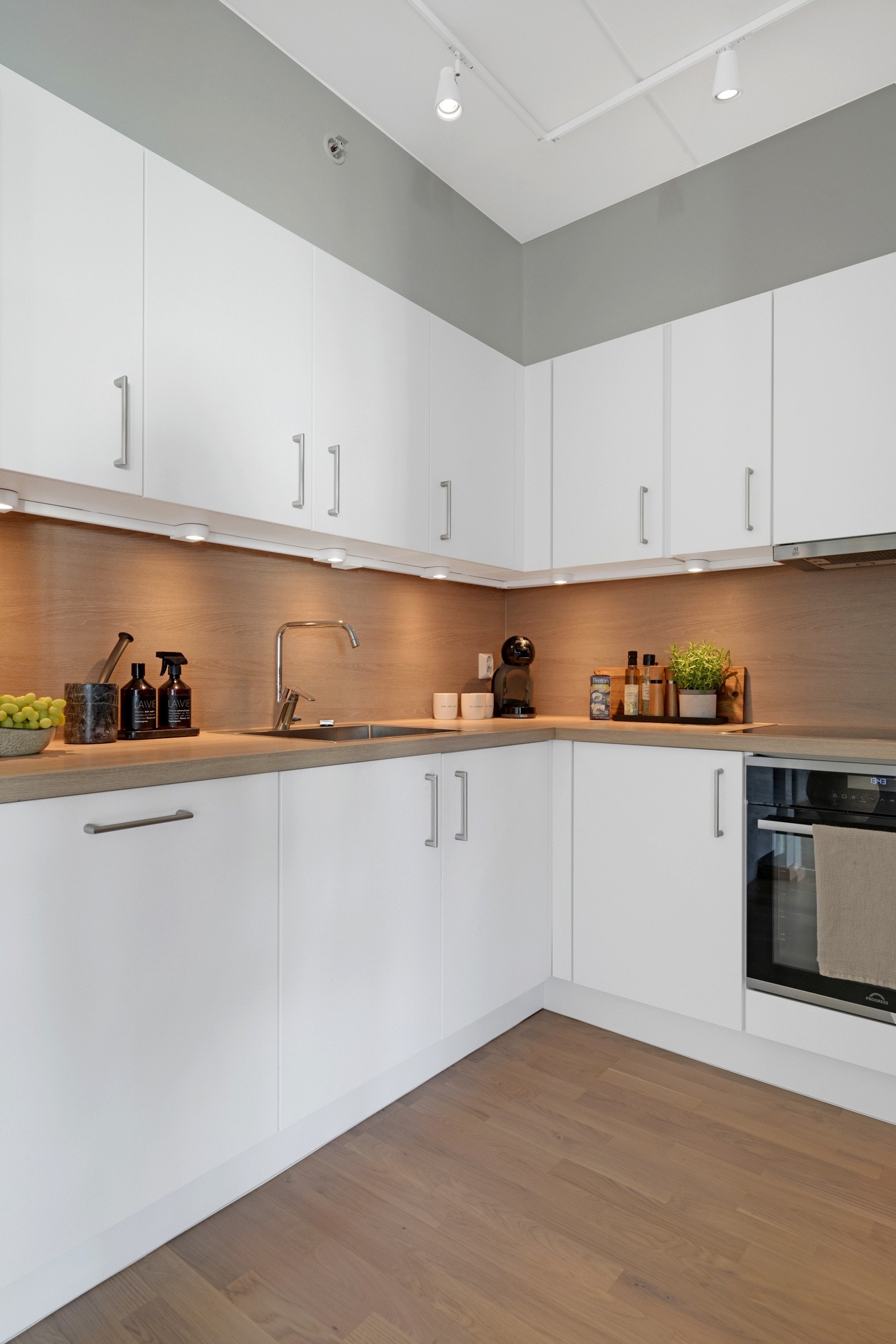 Kjøkkenet inneholder oppvaskkum i stål, nedfelt induksjonstopp, stekeovn, oppvaskmaskin og kjøleskap. Galleribilde