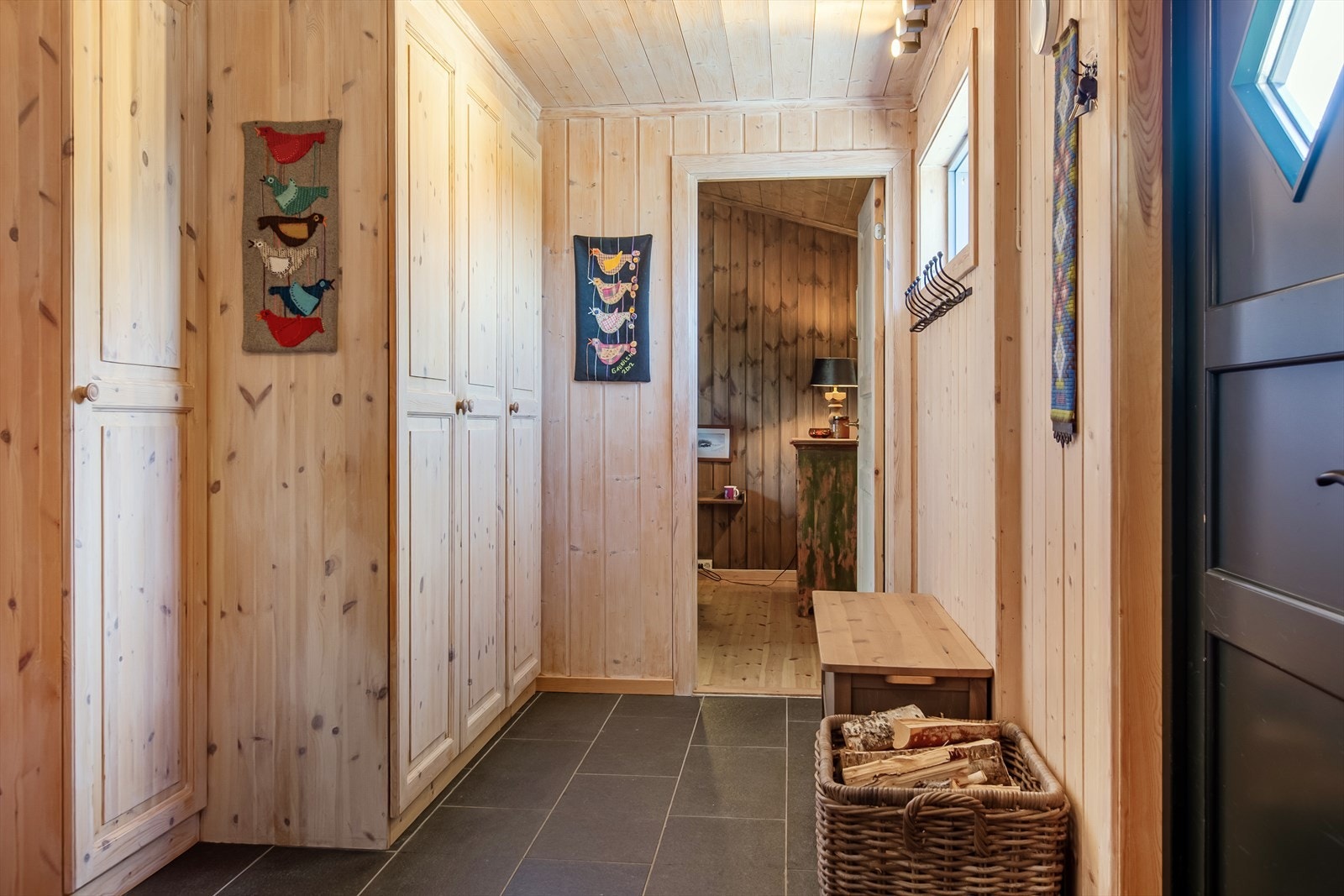 Entréen er romslig og innbydende, med flislagt gulv og varmekabler, samt garderobeløsning for yttertøy og sko. Galleribilde