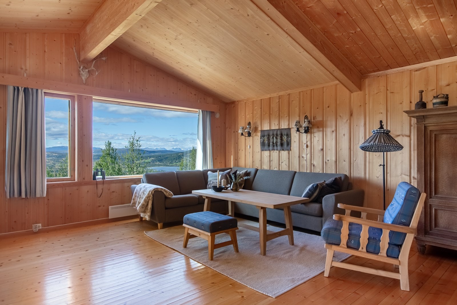 Inne i hytta er det en lys og trivelig stue hvor store vinduer gjør det enkelt å nyte den vakre beliggenheten. Galleribilde