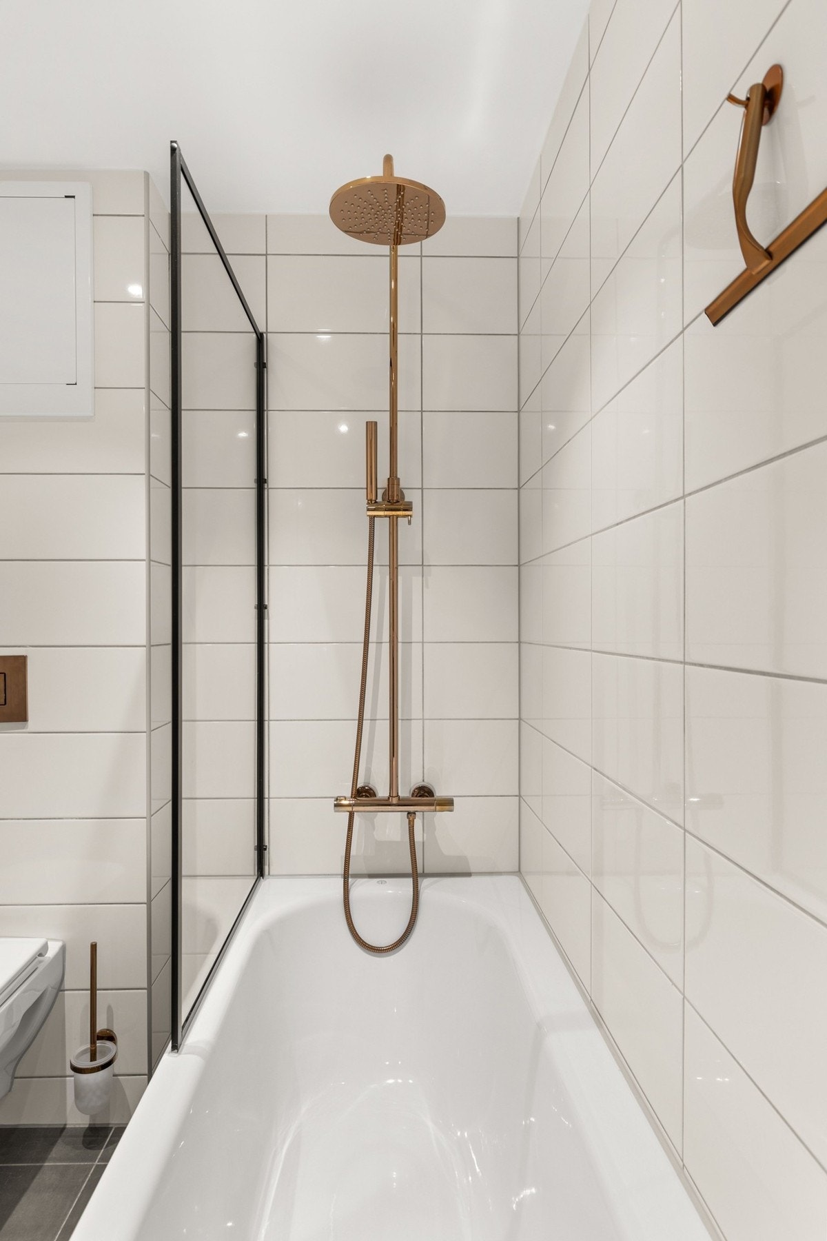 Badet er utstyrt med dusj i badekar, veggfestet klosett og servant. Galleribilde