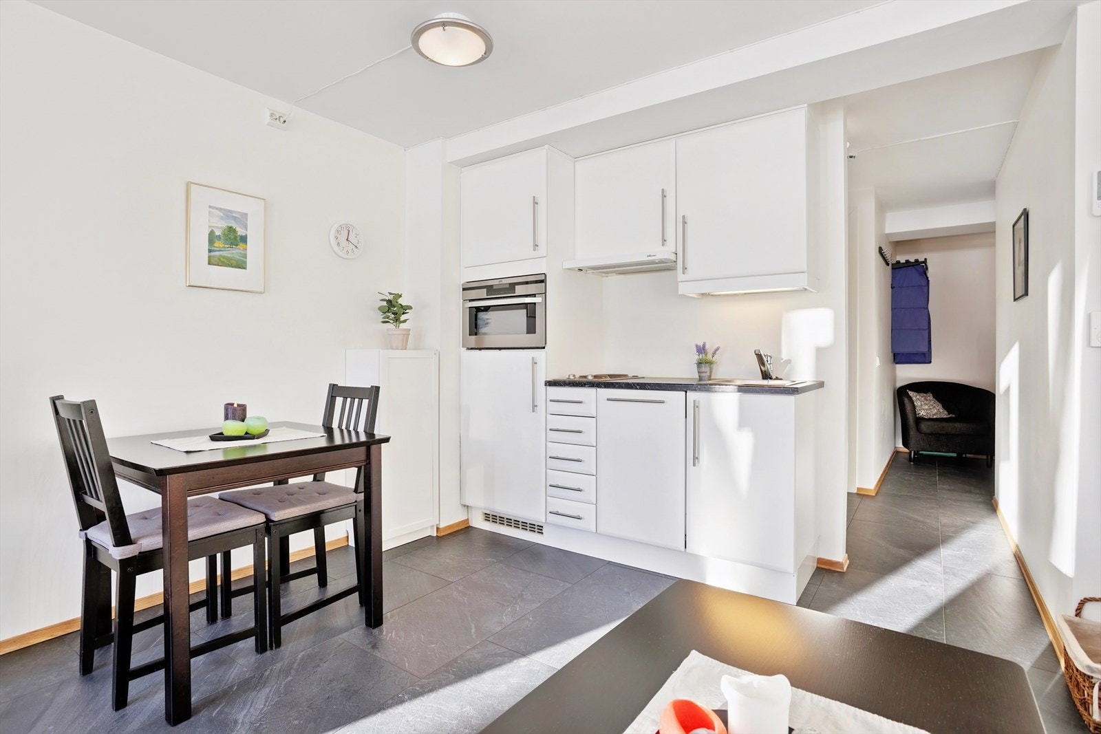 Kjøkkenet er velutstyrt med platetopp, oppvaskmaskin, kjøleskap, kombinert stekeovn/mikrobølgeovn og godt utnyttet lagringsplass Galleribilde