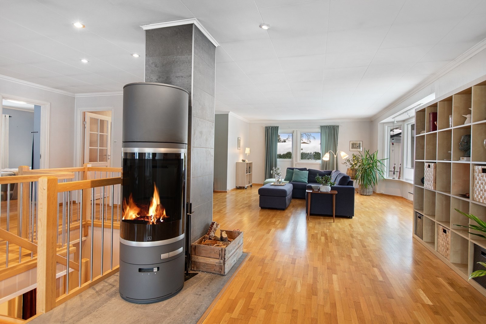 Ildstedet fungerer som et visuelt ankerpunkt i det åpne rommet. Galleribilde