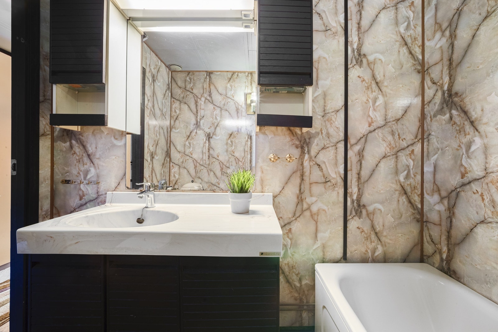 Badet er utstyrt med gulvmontert toalett, badekar og servantskap Galleribilde