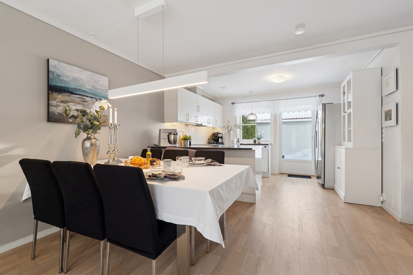 Et naturlig samlingspunkt for en spisestue - praktisk og fint plassert i nærheten av kjøkkenet - parkettgulv og pene overflater Galleribilde