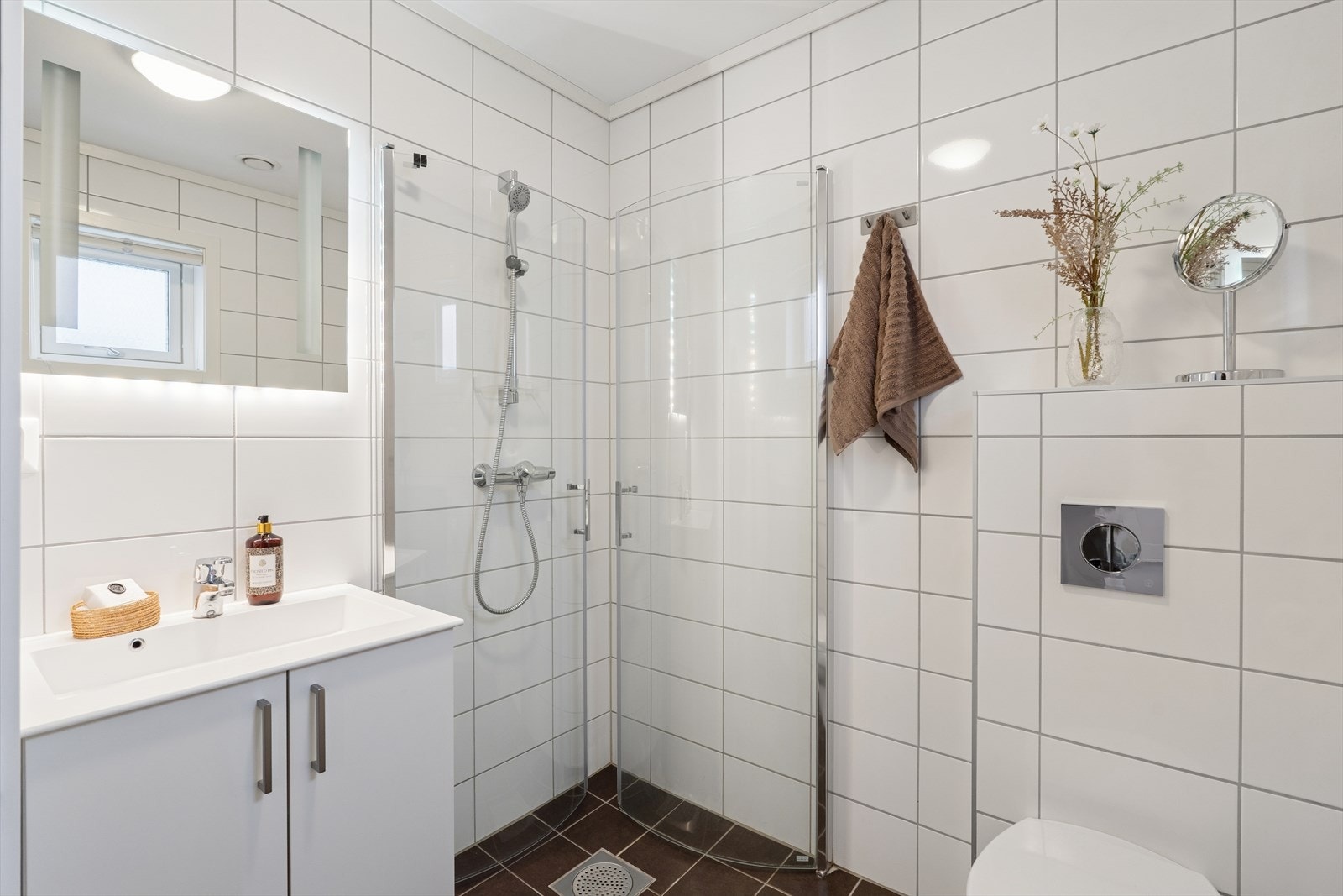 Flott bad/vaskerom i første etasje, rett innenfor hovedinngangen - pent flisevalg på vegger og gulv med gulvvarme. Galleribilde