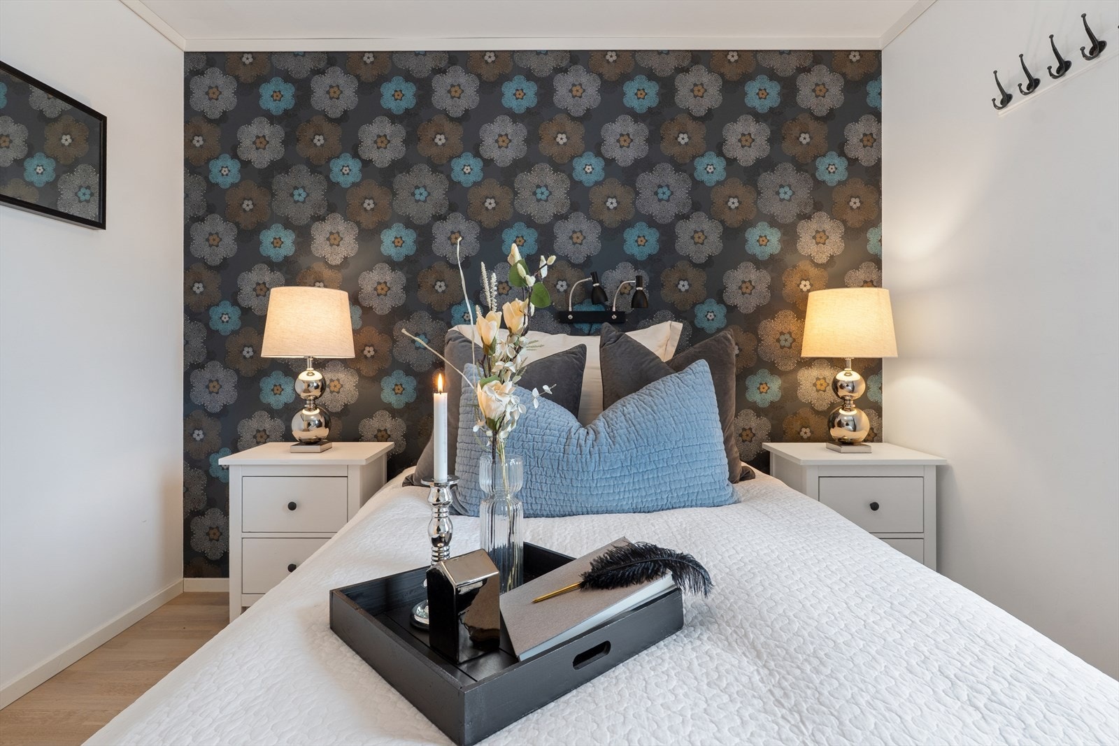 En fondvegg med lekker tapet skaper et godt miljø og muligheter for å innrede med fargede tekstiler i puter og tilbehør Galleribilde