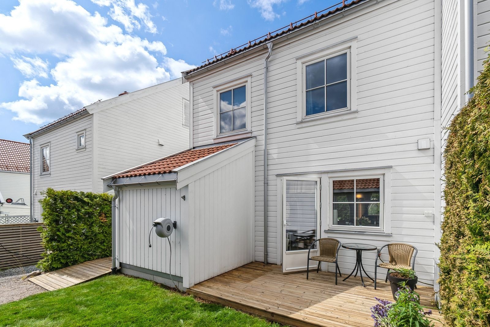 Terrasseplatting med utgang fra kjøkkenet - enkel tilgang til boligen fra gårdsplass og garasje - romslig sportsbod Galleribilde