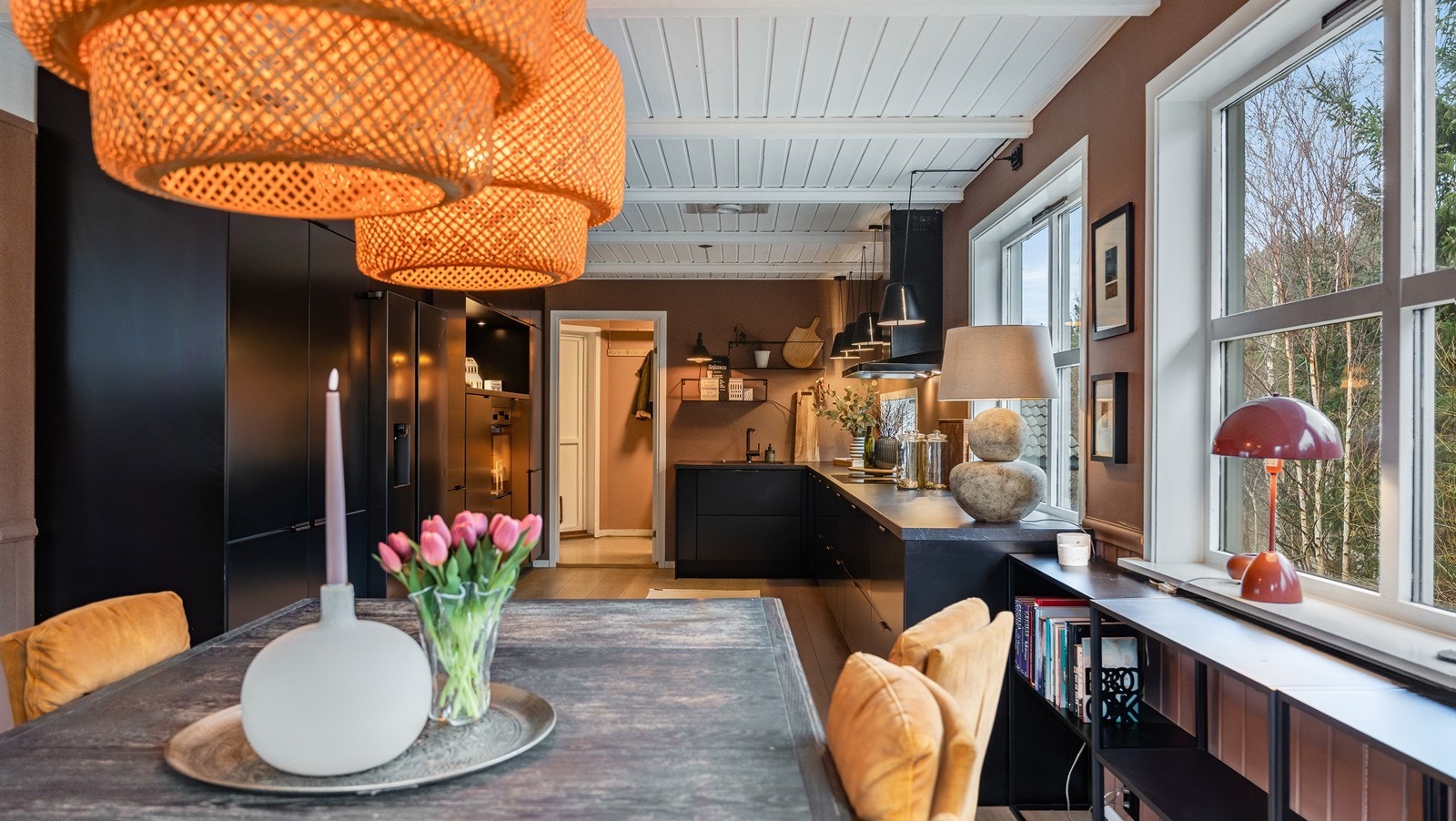 Spisestuen ligger naturlig i enden av kjøkkenet, der store vindusflater slipper inn godt med dagslys og skaper en hyggelig ramme rundt måltidene. Galleribilde