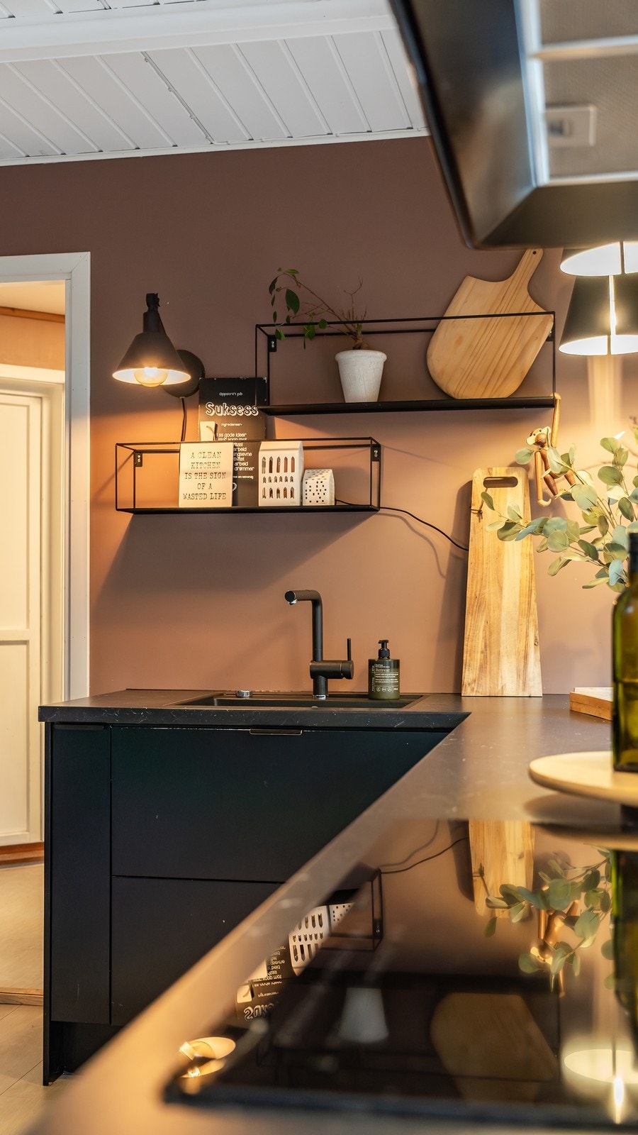 Den sorte innredningen mot den varme fargen på veggen skaper en vakker kontrast som tilfører både dybde og karakter. Galleribilde