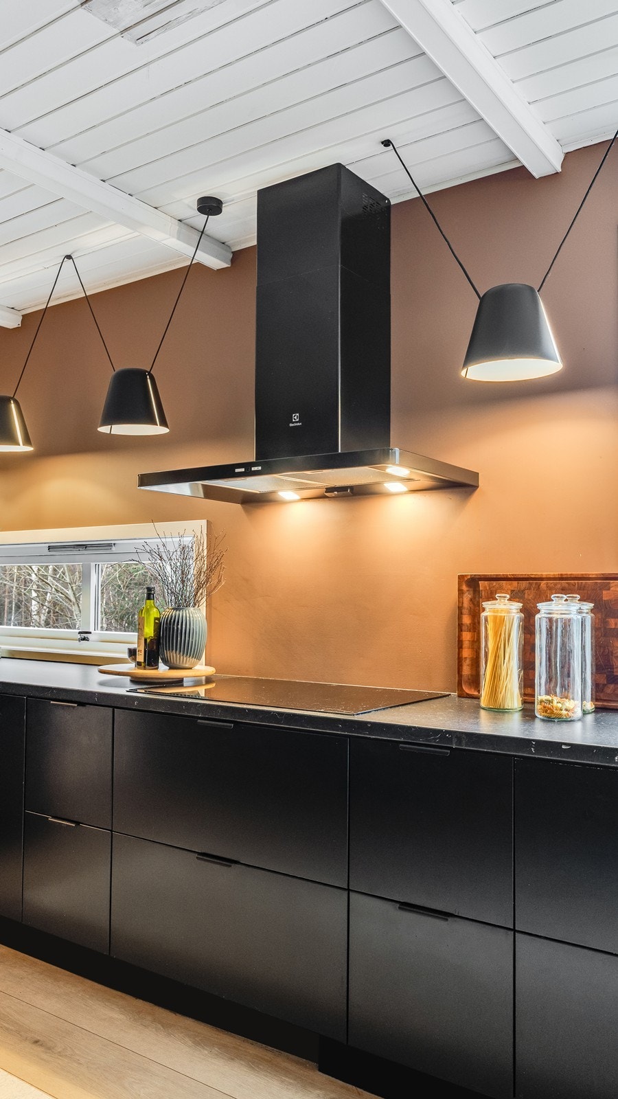 Stilige lamper over kjøkkenbenk tilfører et eksklusivt blikkfang og kompletterer kjøkkenets helhetlige stil. Galleribilde