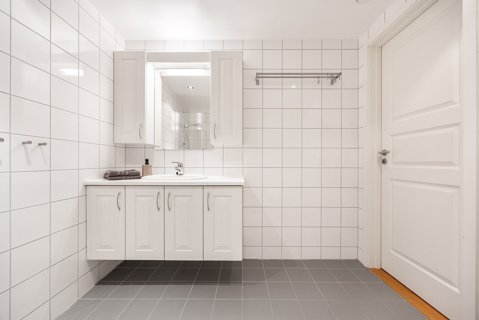 Baderomsinnredning med servant og godt med oppbevaringsplass i skap. Galleribilde