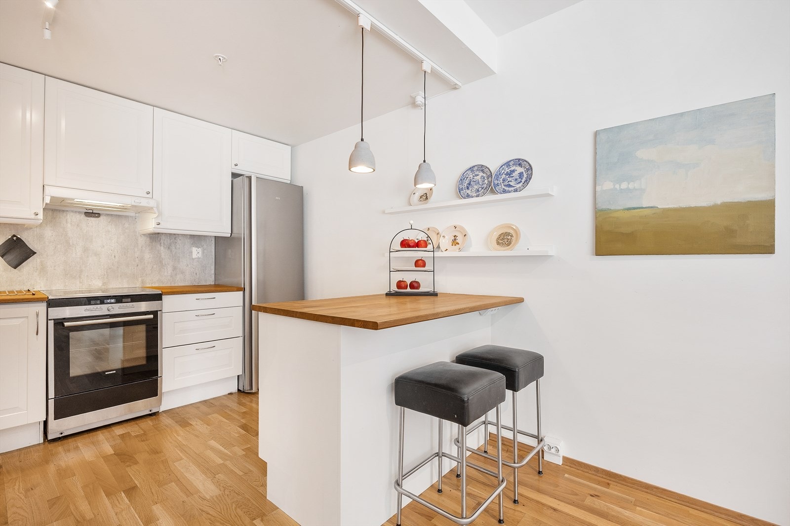 Kjøkkenøya fungerer som en ekstra arbeidsflate og en uformell spiseplass. Galleribilde