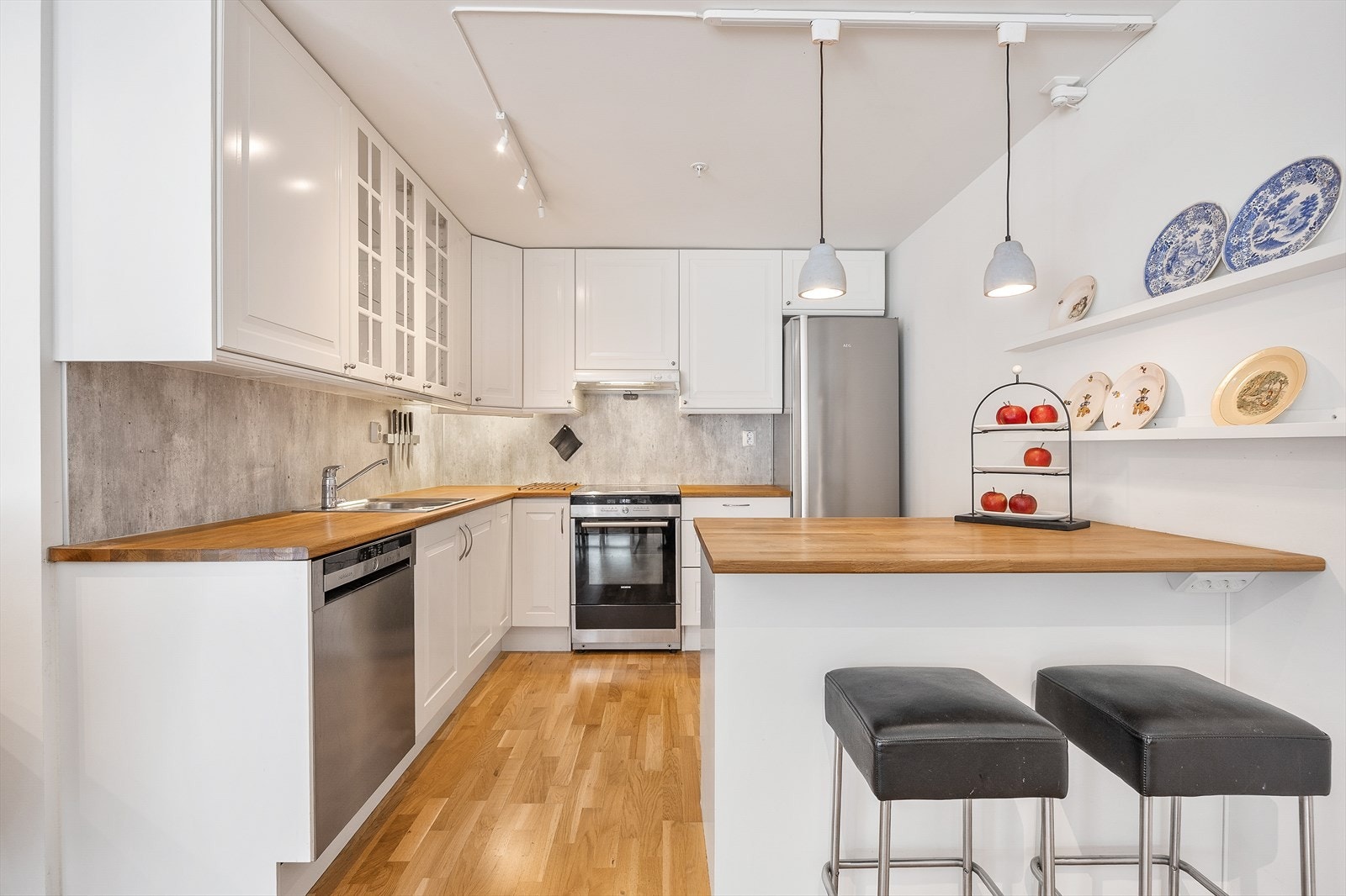 Den åpne stue- og kjøkkenløsningen gir en luftig og sosial sone med plass til flere møbelgrupper. Galleribilde