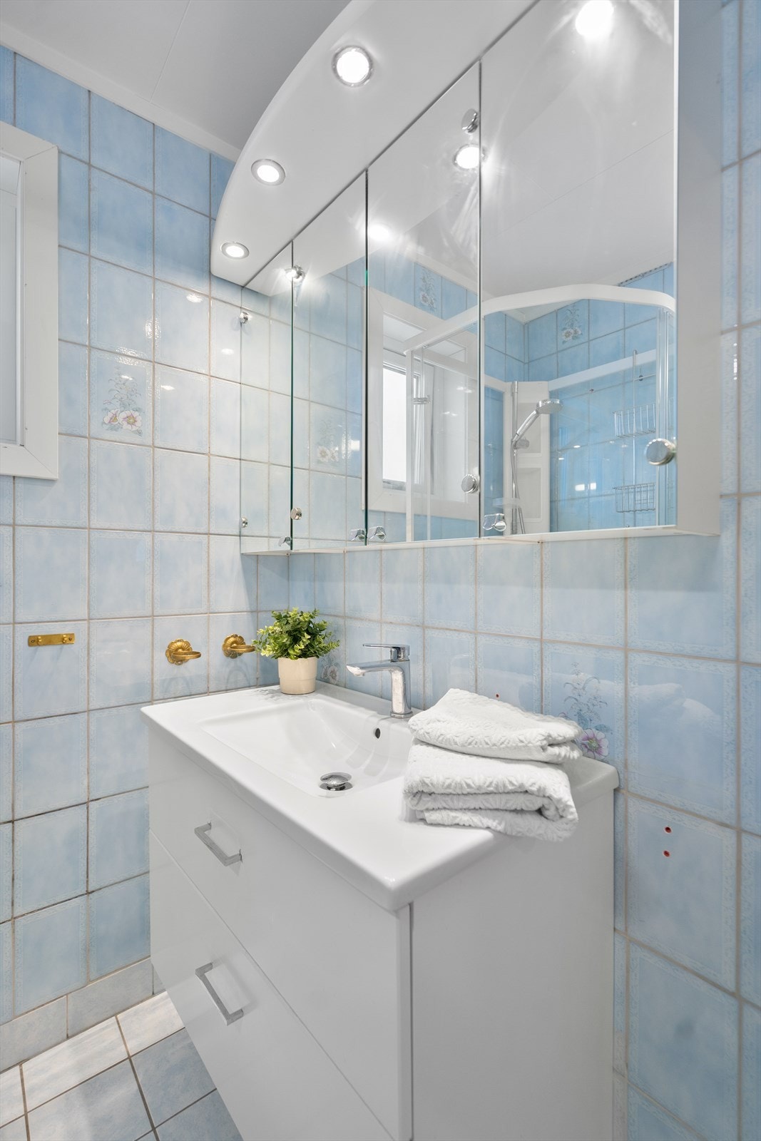 Badet er utstyrt med innredning, speilskap, dusjkabinett, toalett Galleribilde