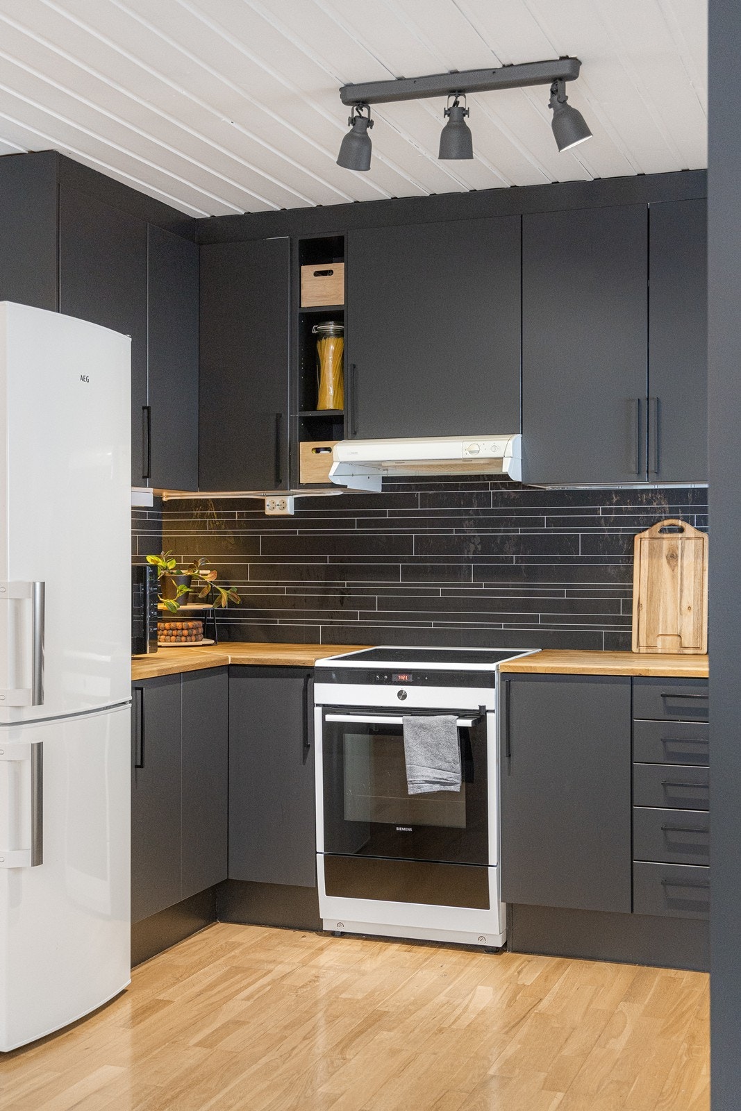 Innredningen har sorte, glatte fronter, heltre benkeplate og dobbel oppvaskkum i stål. Galleribilde