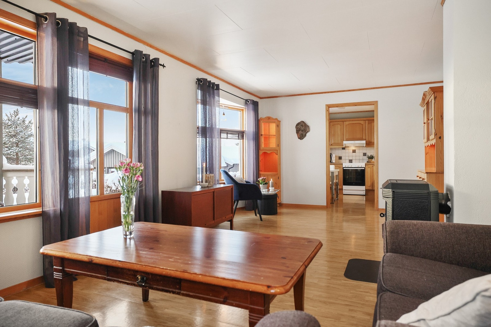 Stue og kjøkke ligger i front av leiligheten - med store vindusflater Galleribilde