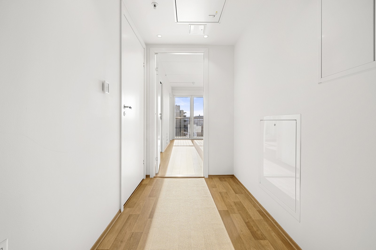 Herfra ledes du inn til boligens sentrale samlingspunkt, med gjennomgående parkett på gulvet. Galleribilde