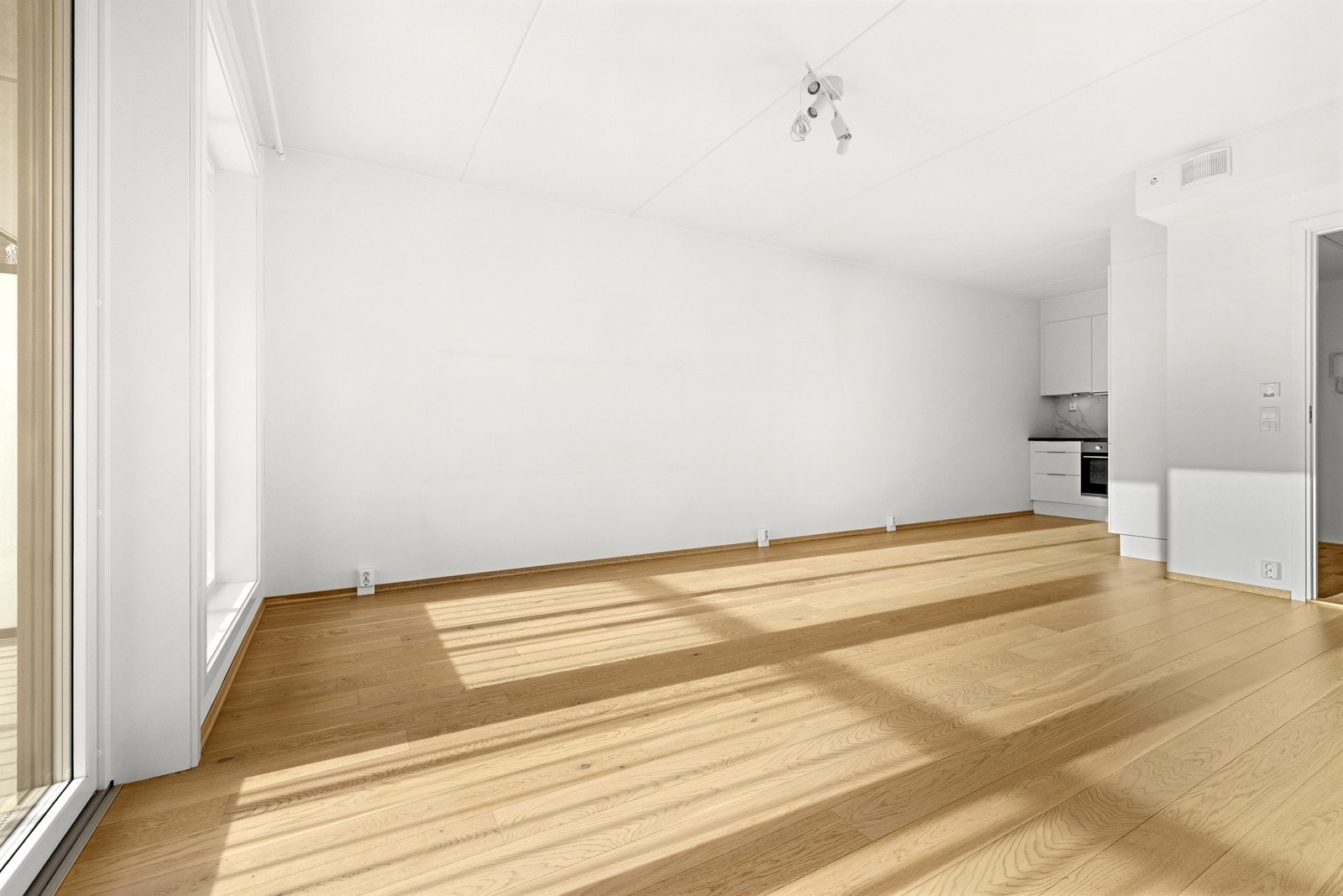 Gjennomgående parkettgulv og lyse, malte flater gir et helhetlig og moderne inntrykk. Galleribilde