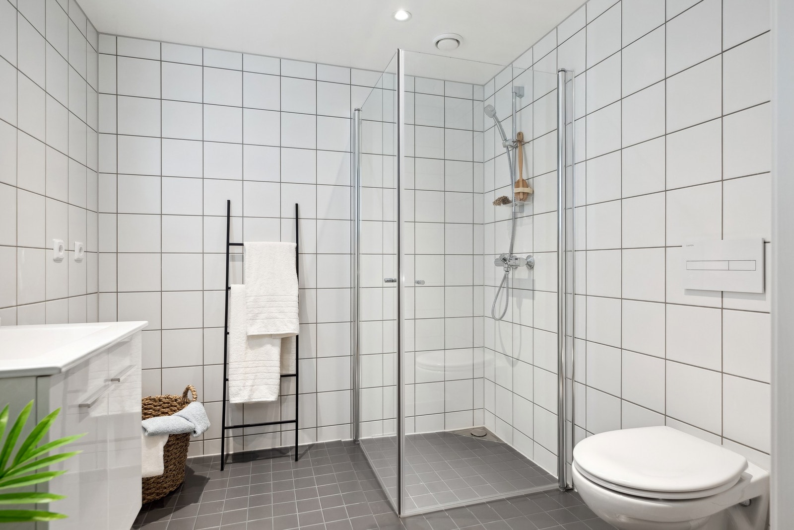 Pen baderomsinnredning med lagringsplass og opplegg til vaskemaskin. Galleribilde