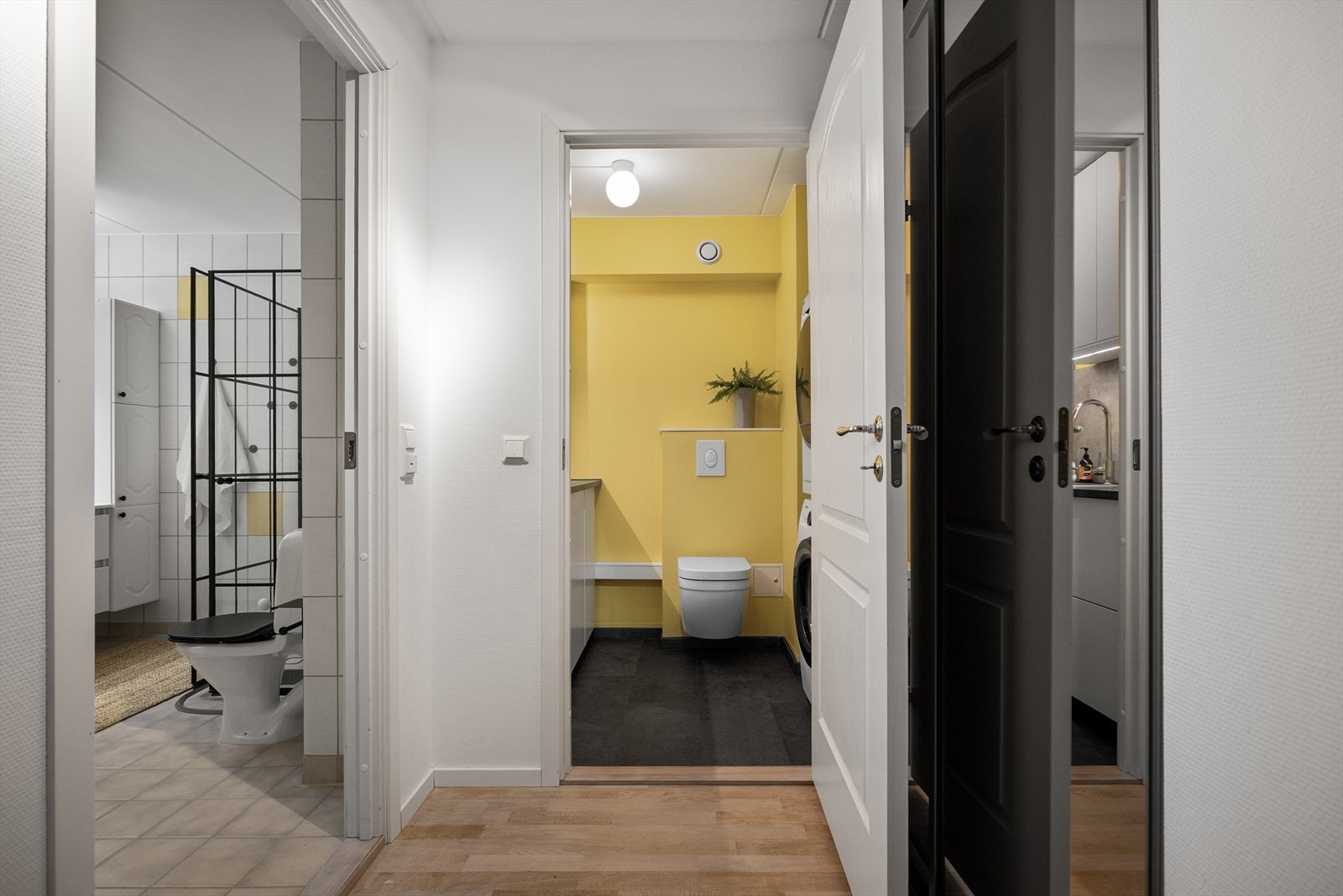 Ute i en liten sidegang finner du en romslig innebygd speilgarderobe. Her ligger også kombinert vaskerom og WC fra 2024 _ et nydelig gult rom, med ekstremt fin utnyttelse av plassen. Galleribilde