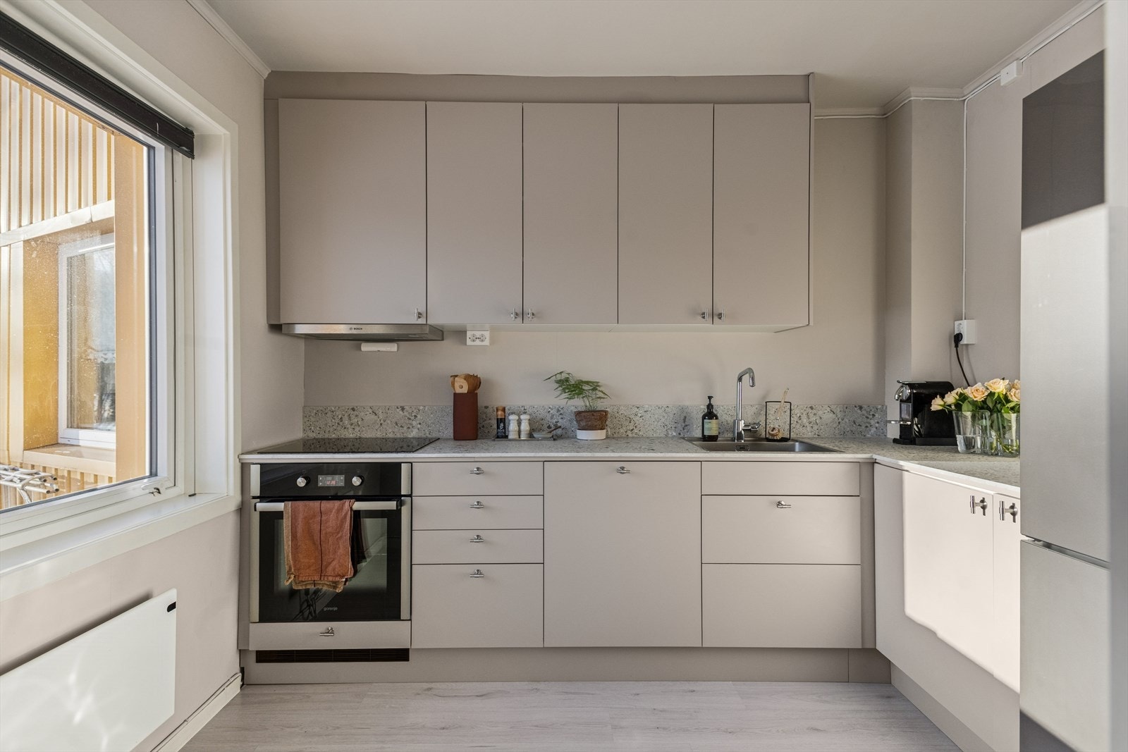 Kjøkkenet ble byttet i 2025 og er lekkert innredet med grå, slette fronter og gråmelert benkeplate i laminat. Et godt utnyttet kjøkken hvor man får godt med skap- og skuffeplass, samt gode arbeidsflater på benk. Galleribilde