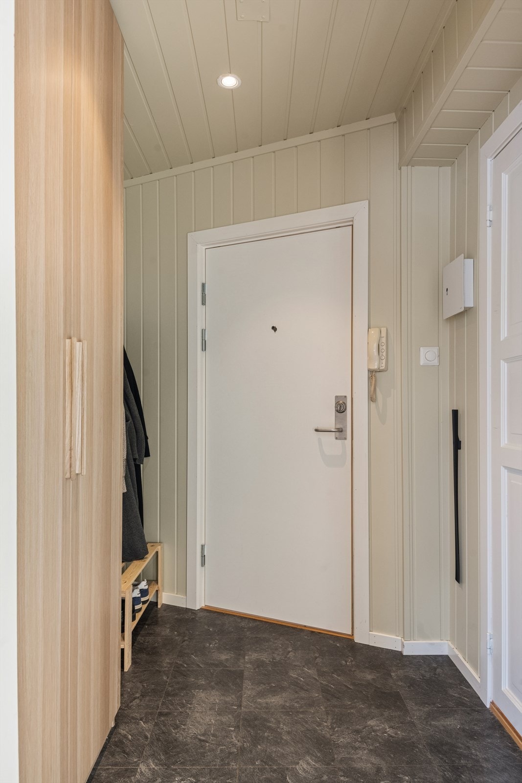 Man ønskes velkommen inn i en lys og romslig entré som er praktisk innredet med belegg på gulv og garderobeskap hvor man har god plass til å henge fra seg yttertøy og sko. Galleribilde