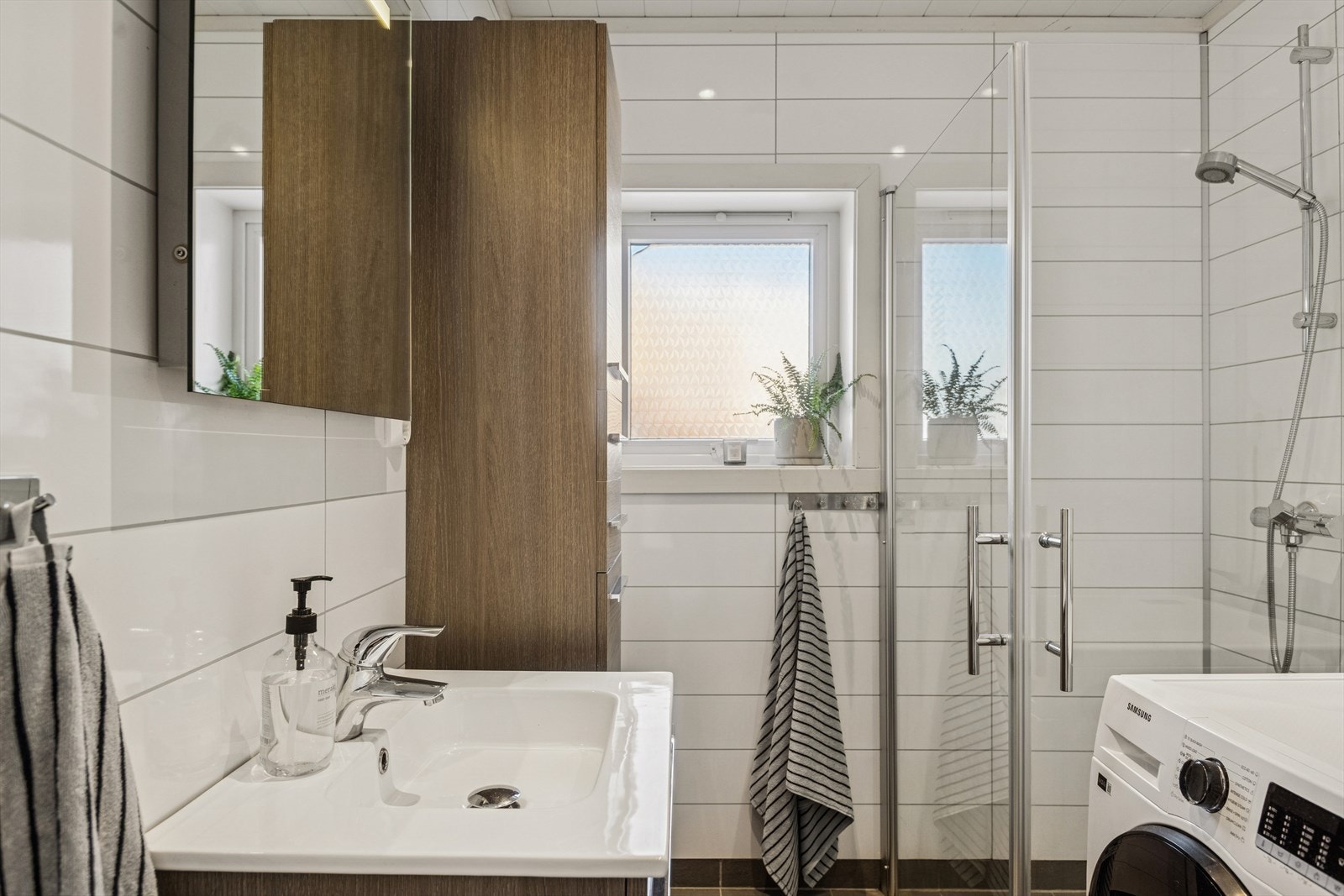 Badet er ellers utstyrt med dusjhjørne, toalett og baderomsinnredning med god lagringsplass og nedfelt servant. I tillegg har man opplegg for vaskemaskin. Galleribilde