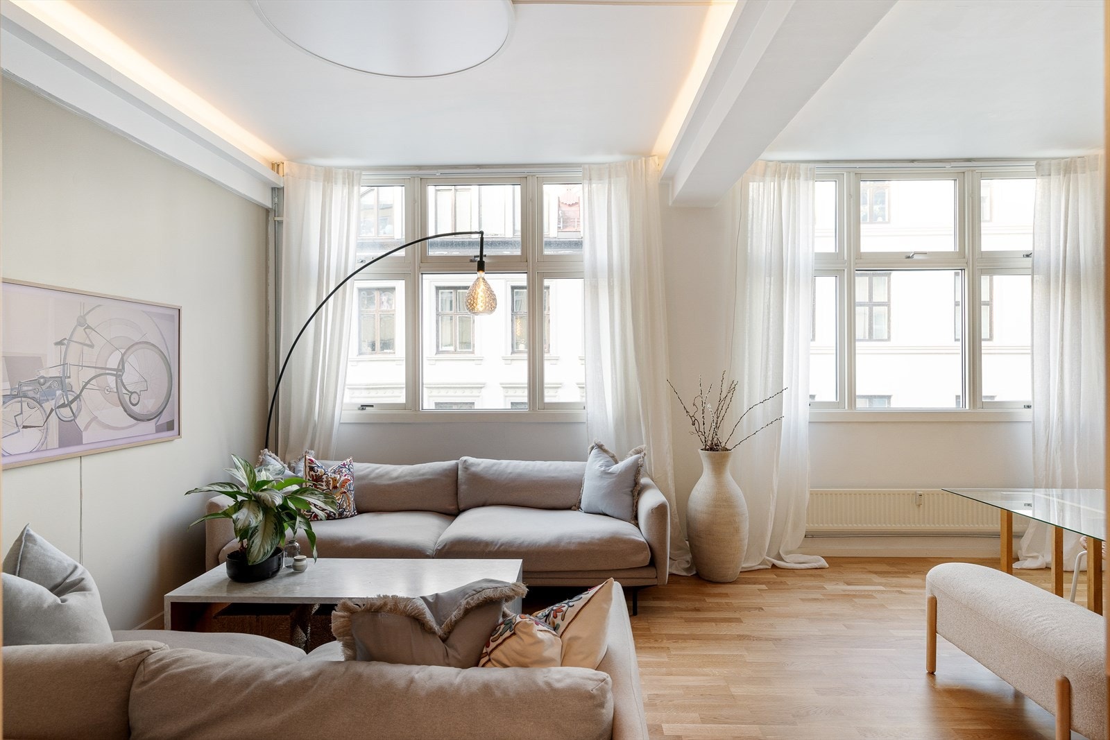 Stuen er romslig og harmonisk med generøs takhøyde og brede vindusflater som gir godt naturlig lys gjennom hele dagen. Galleribilde