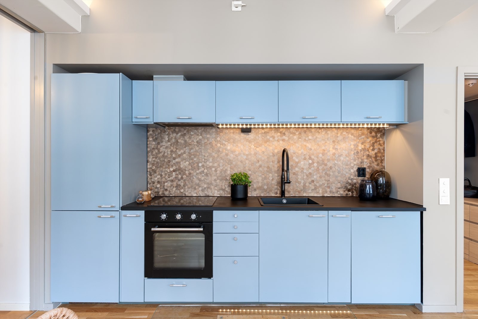 Mørk benkeplate og flislagt bakvegg gir et moderne preg og praktiske arbeidsflater. Galleribilde