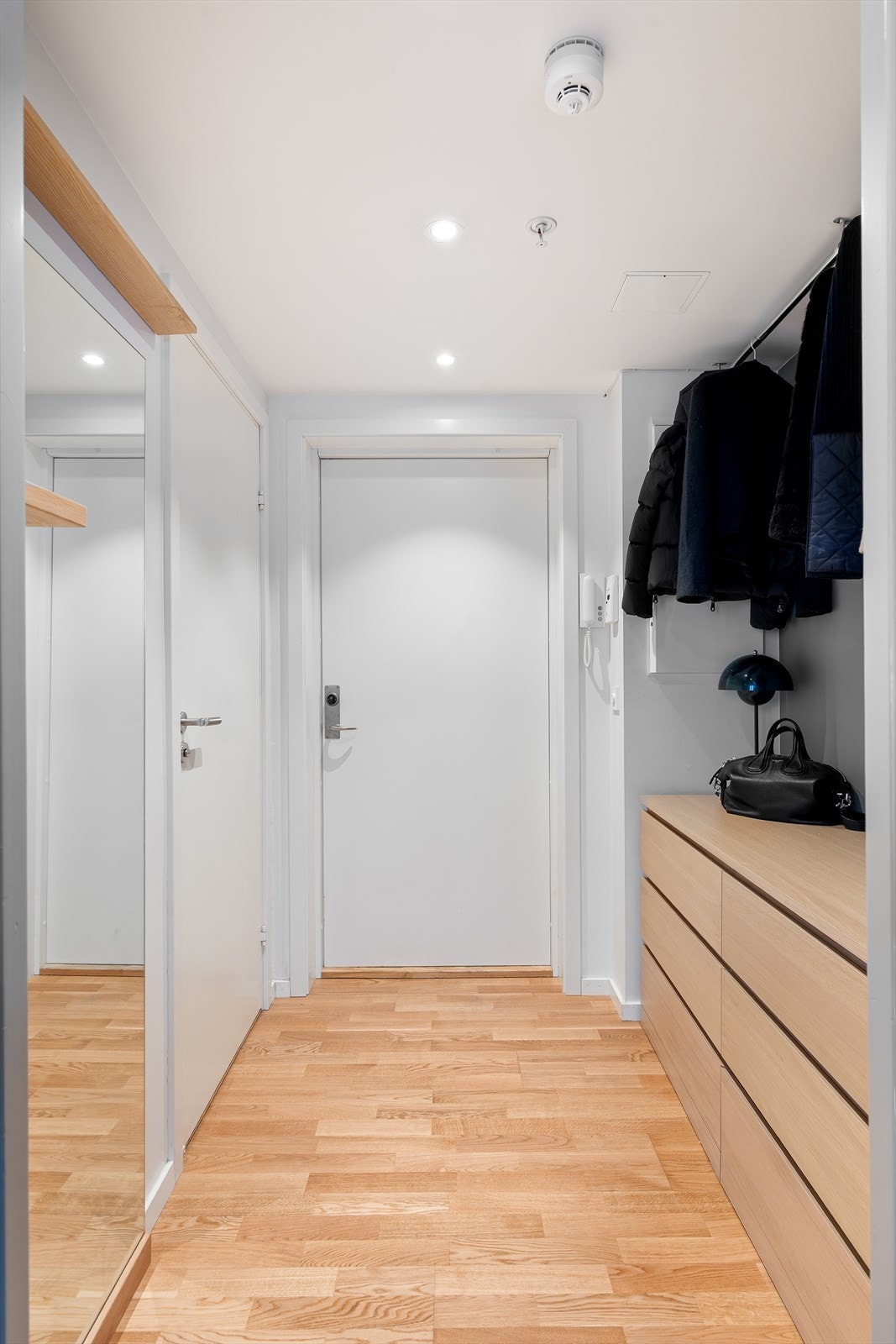 Leiligheten har en innbydende entré med downlights i himlingen, noe som skaper et umiddelbart godt førsteinntrykk. Galleribilde