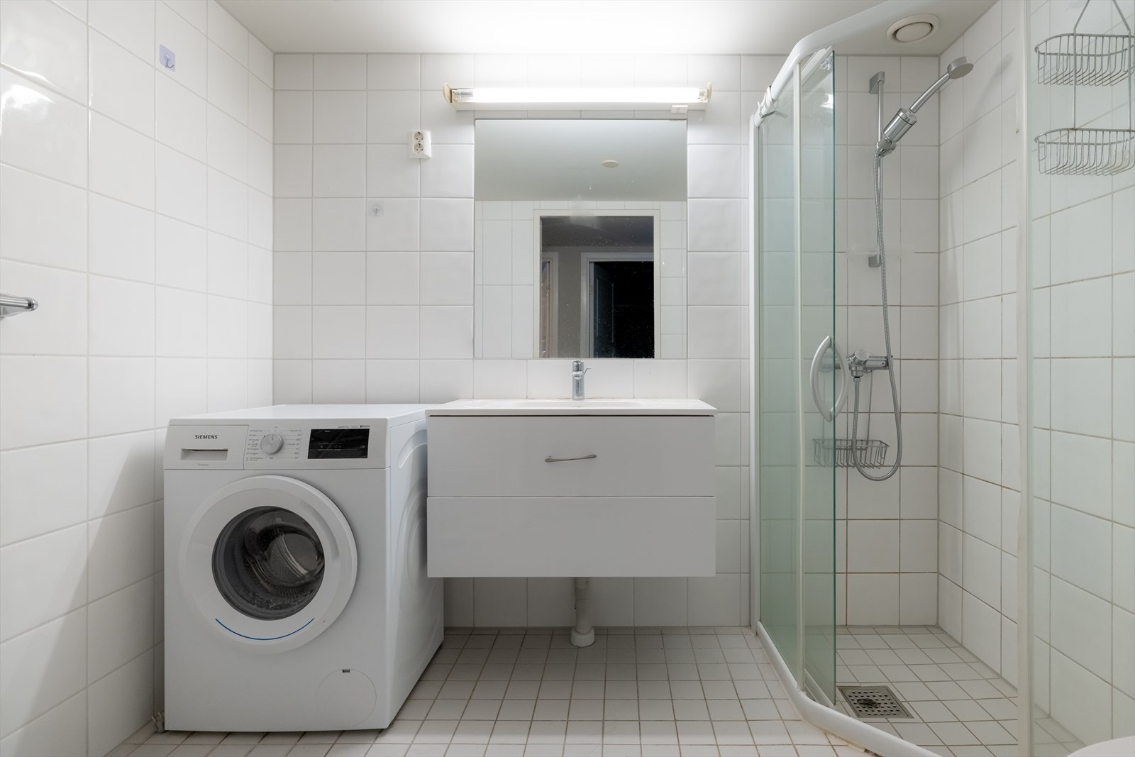 Rommet har dusjhjørne med glassvegger, vegghengt toalett og ny baderomsinnredning med nedfelt servant og slette fronter. Galleribilde